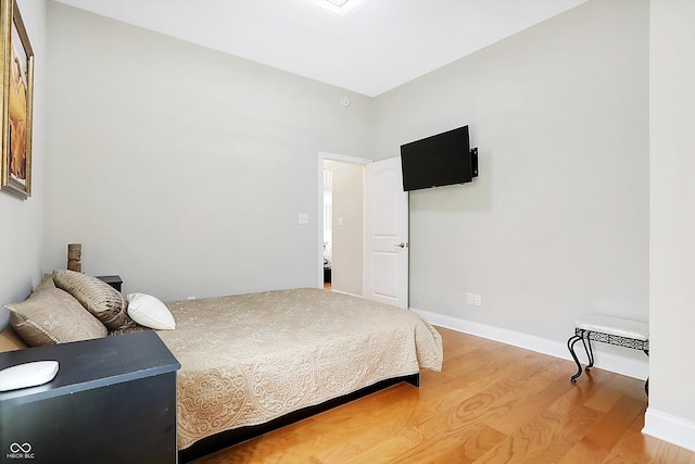 bedroom with light wood finished floors and baseboards