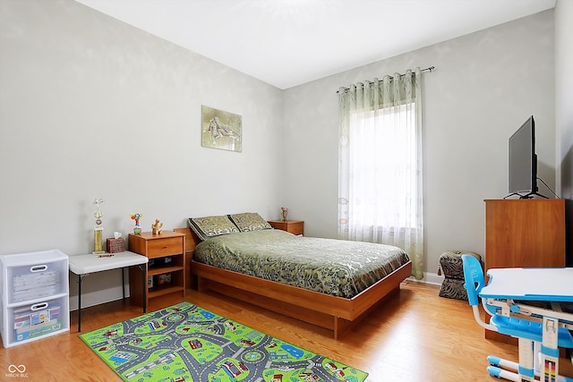 bedroom with wood finished floors and baseboards