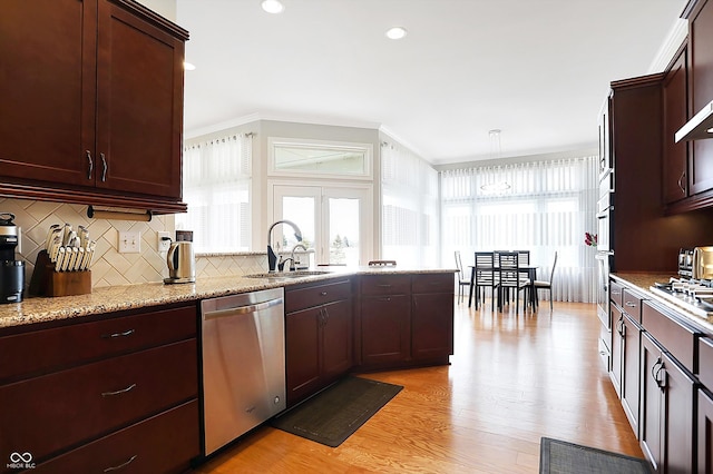 kitchen featuring crown molding, decorative backsplash, stainless steel dishwasher, light wood-style floors, and a sink