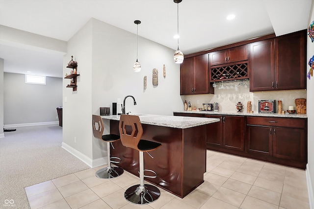 bar with light tile patterned flooring, baseboards, wet bar, tasteful backsplash, and decorative light fixtures