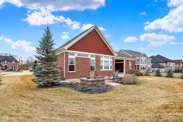 back of property featuring a patio area, a residential view, a lawn, and brick siding