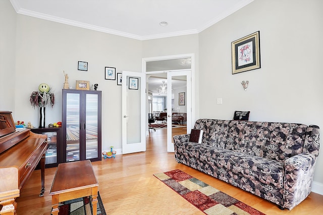 living area featuring baseboards, french doors, wood finished floors, and crown molding