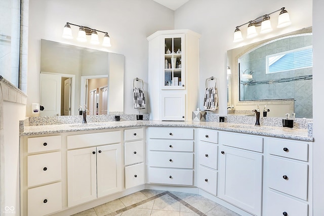 bathroom with two vanities, a sink, and a walk in shower