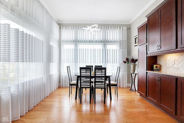 dining room with crown molding and light wood finished floors