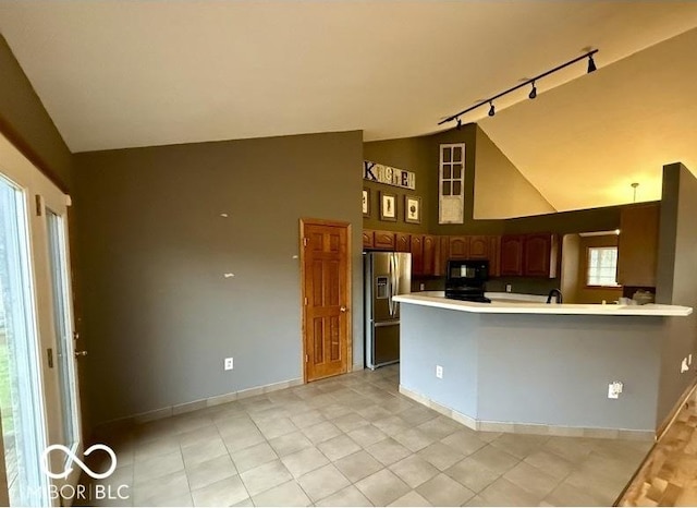 130 Hanover Dr, Morristown, IN 46161 - kitchen featuring stainless steel refrigerator with ice dispenser, black microwave, track lighting, high vaulted ceiling, and a peninsula