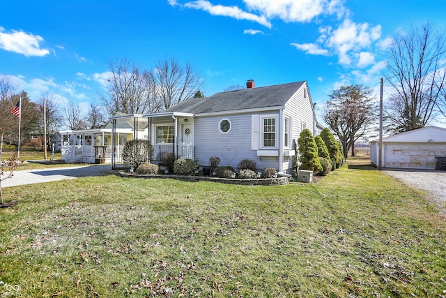 view of front of house with a chimney, covered porch, an outdoor structure, and a front lawn