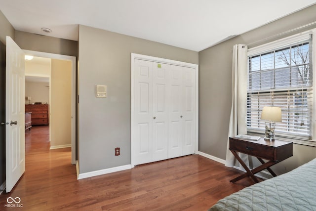 bedroom with a closet, baseboards, and wood finished floors