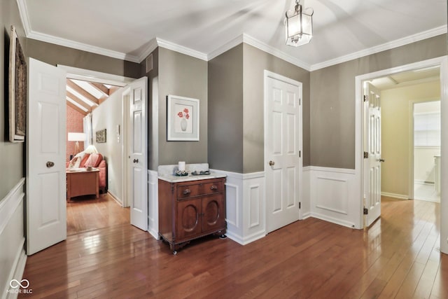 corridor featuring hardwood / wood-style floors, crown molding, and wainscoting