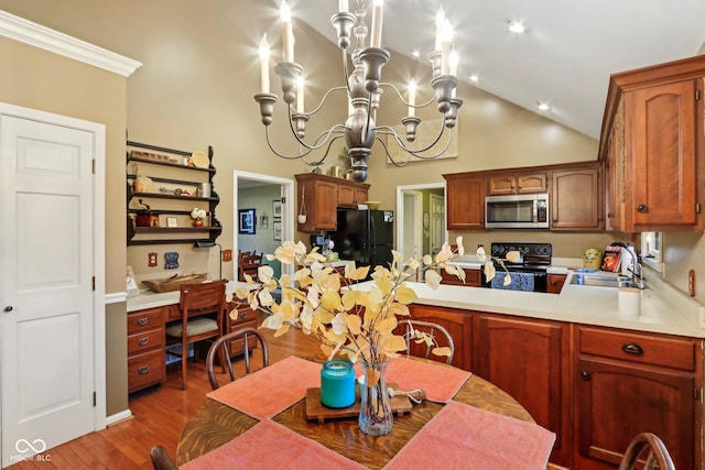 kitchen featuring a chandelier, light countertops, vaulted ceiling, black appliances, and a sink