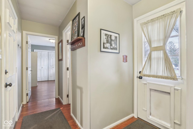 hall with dark wood-type flooring and baseboards