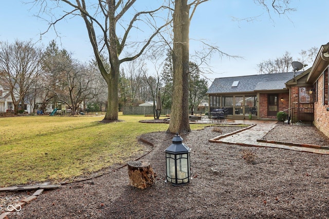 view of yard featuring a playground, a patio area, and fence