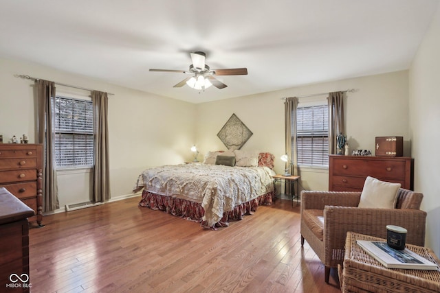 bedroom featuring multiple windows, baseboards, and wood-type flooring