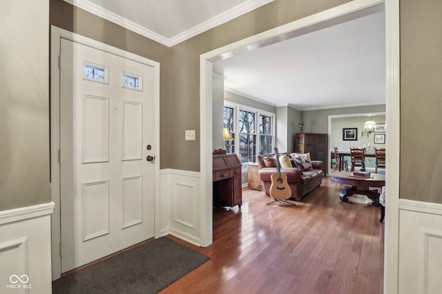 entryway featuring wainscoting, ornamental molding, and dark wood-style flooring