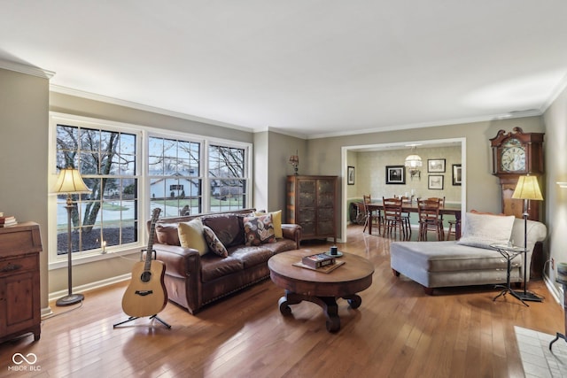 living area featuring hardwood / wood-style floors, baseboards, and ornamental molding