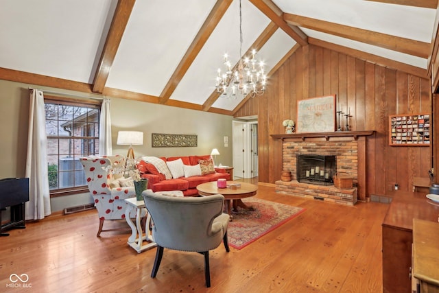 living room with hardwood / wood-style floors, beam ceiling, and a brick fireplace