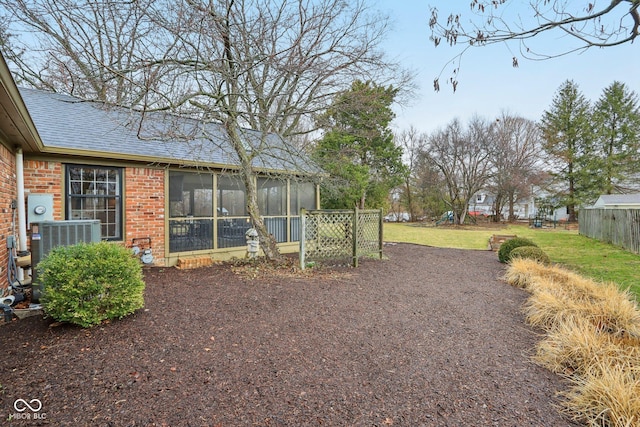 view of yard featuring cooling unit, fence, and a sunroom