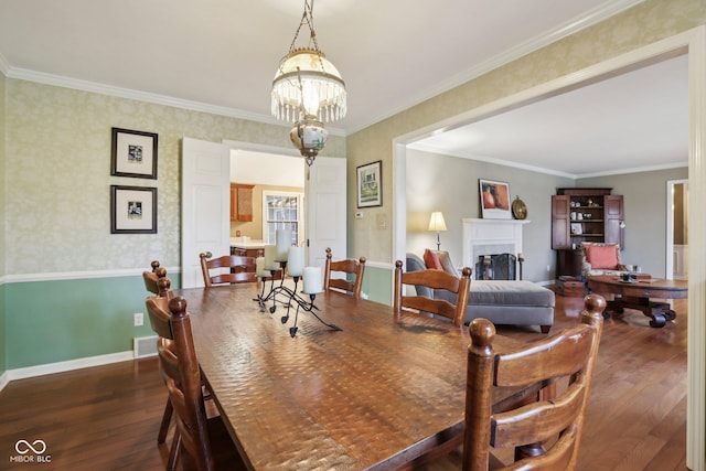 dining area featuring ornamental molding, a fireplace, and dark wood-style flooring