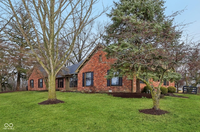 view of front of property with crawl space, brick siding, and a front lawn