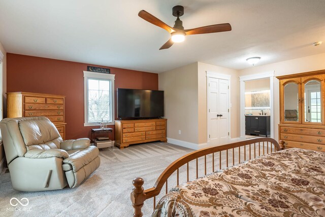 bedroom featuring a closet, light carpet, ceiling fan, and baseboards