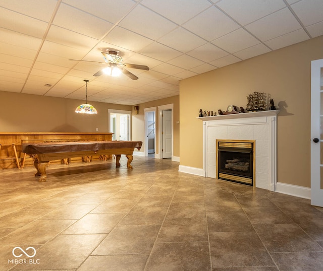 game room with pool table, baseboards, a drop ceiling, and a tiled fireplace