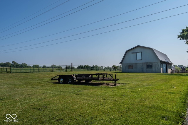 view of yard featuring a barn, fence, and an outbuilding