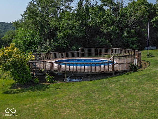 view of pool featuring a fenced in pool, a yard, and a deck