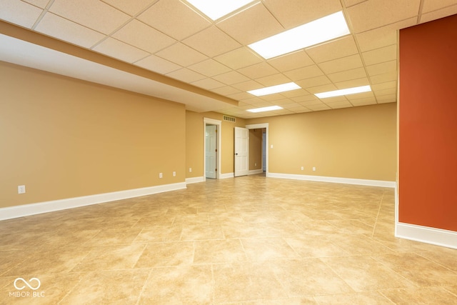 unfurnished room with a paneled ceiling, visible vents, and baseboards