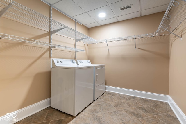 laundry room with laundry area, separate washer and dryer, visible vents, and baseboards