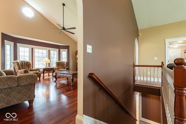 stairs with high vaulted ceiling, wood finished floors, and a ceiling fan