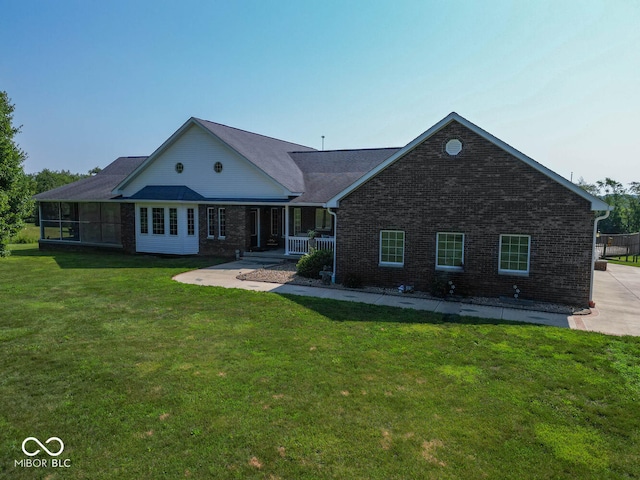 view of front of home with a front yard, a porch, and brick siding