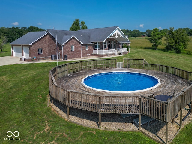 view of swimming pool with a fenced in pool, a lawn, and a wooden deck