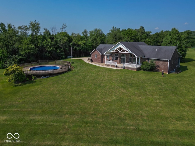 exterior space with a trampoline, a view of trees, and a lawn