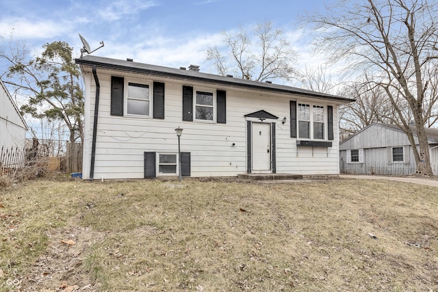 bi-level home with a front yard and fence