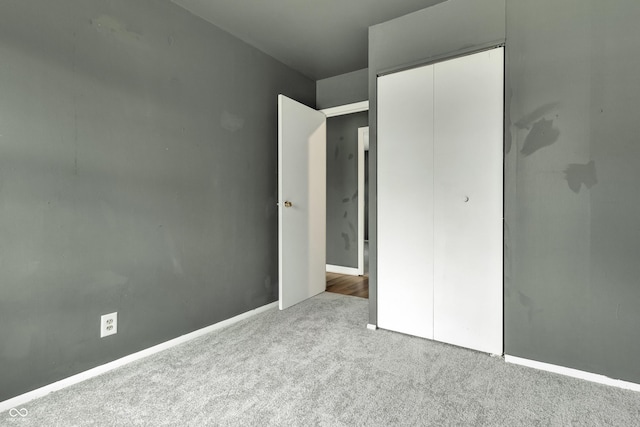 unfurnished bedroom featuring carpet floors, a closet, and baseboards