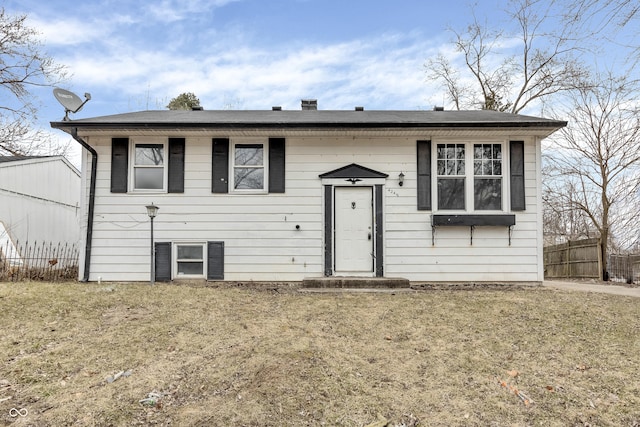 split foyer home with fence and a front yard