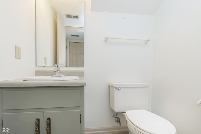 bathroom with visible vents, vanity, and toilet