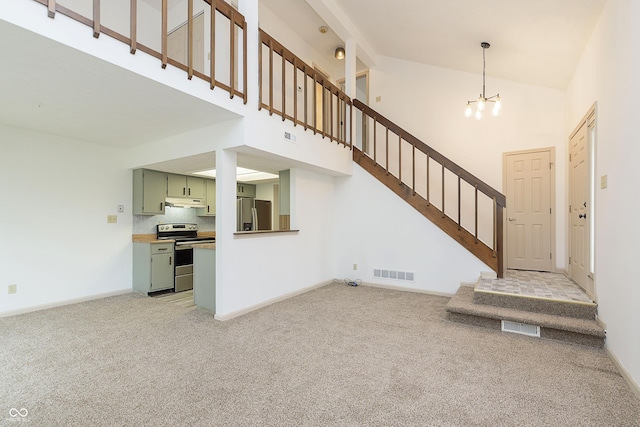 interior space featuring visible vents, light colored carpet, stairway, an inviting chandelier, and high vaulted ceiling