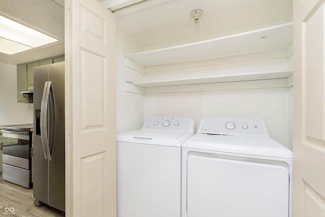 laundry area featuring laundry area, light wood-style flooring, and washer and dryer