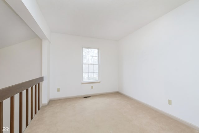 spare room with light carpet, baseboards, and visible vents