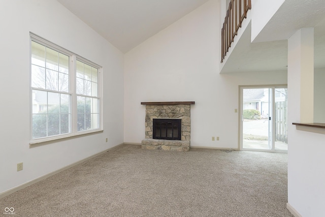 unfurnished living room featuring baseboards, a fireplace, high vaulted ceiling, and carpet flooring