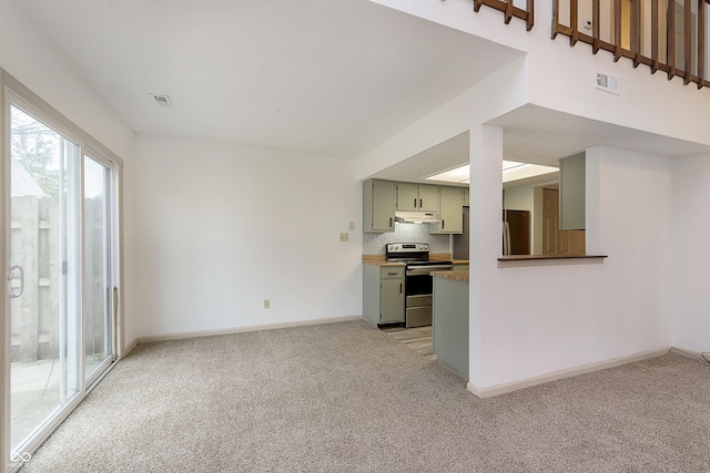 unfurnished living room with baseboards, visible vents, and light colored carpet