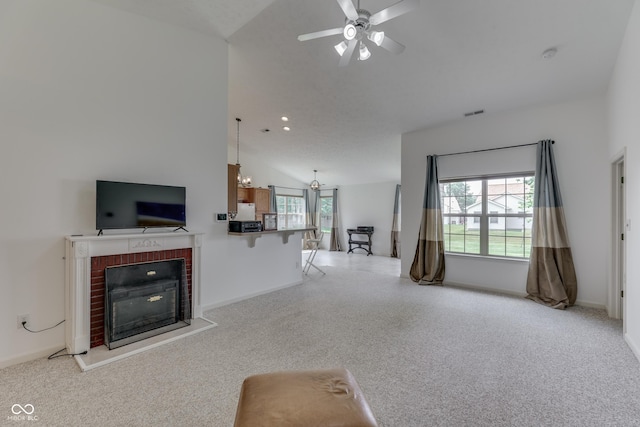 unfurnished living room with lofted ceiling, a brick fireplace, baseboards, and ceiling fan with notable chandelier