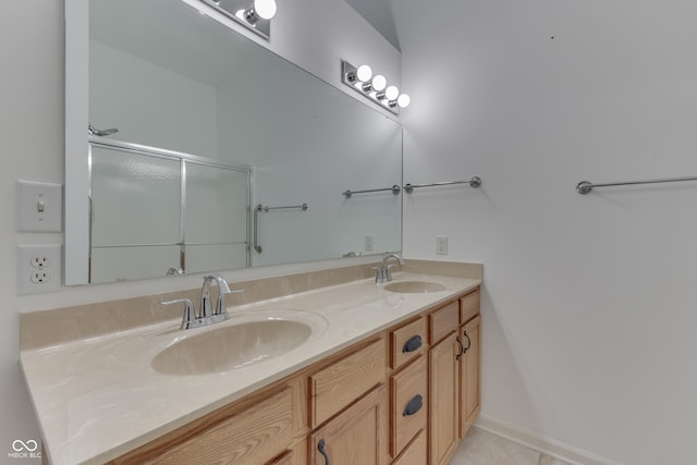 bathroom with tile patterned floors, a shower with door, a sink, and double vanity