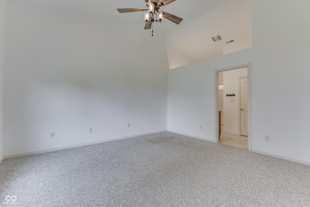 empty room with light carpet, baseboards, visible vents, a ceiling fan, and vaulted ceiling