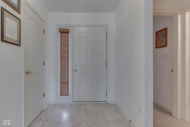 entryway with baseboards and light tile patterned floors