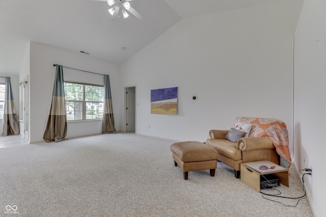 living area with high vaulted ceiling, light colored carpet, visible vents, and a ceiling fan