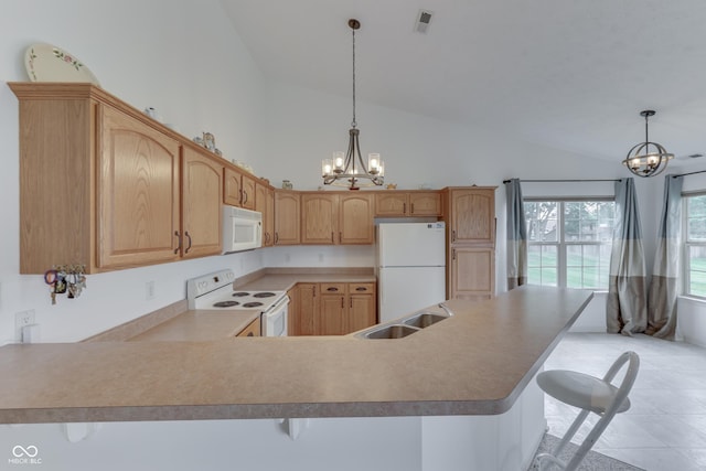 kitchen with white appliances, visible vents, a kitchen breakfast bar, a peninsula, and a chandelier