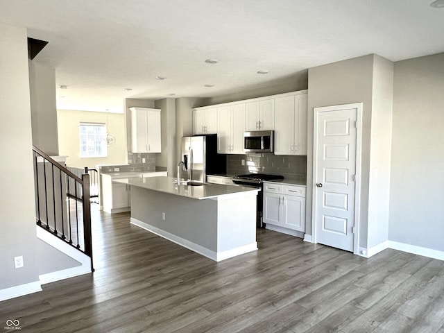 kitchen featuring dark wood finished floors, baseboards, backsplash, and stainless steel appliances