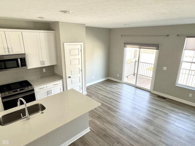 kitchen with visible vents, a healthy amount of sunlight, appliances with stainless steel finishes, and a sink