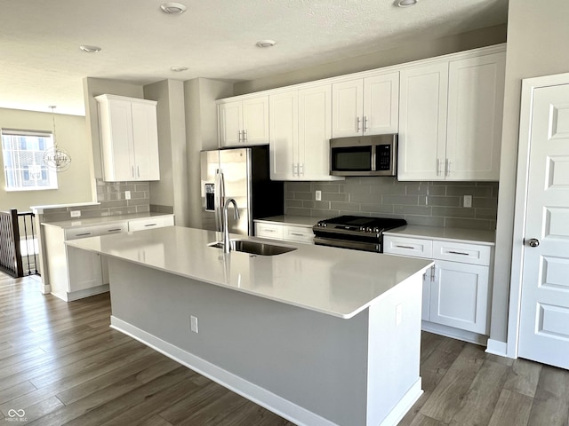 kitchen featuring a sink, dark wood-style floors, white cabinetry, appliances with stainless steel finishes, and light countertops